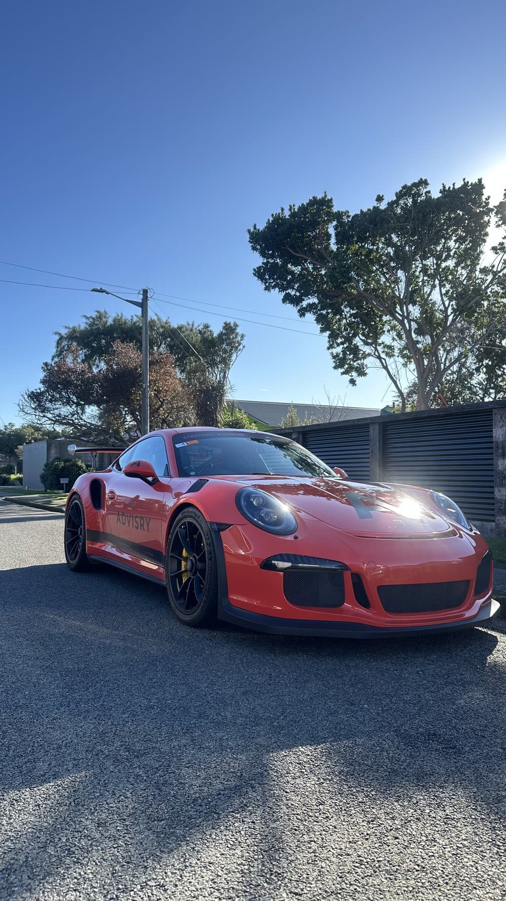 The Advisry race car parked on a sunny street