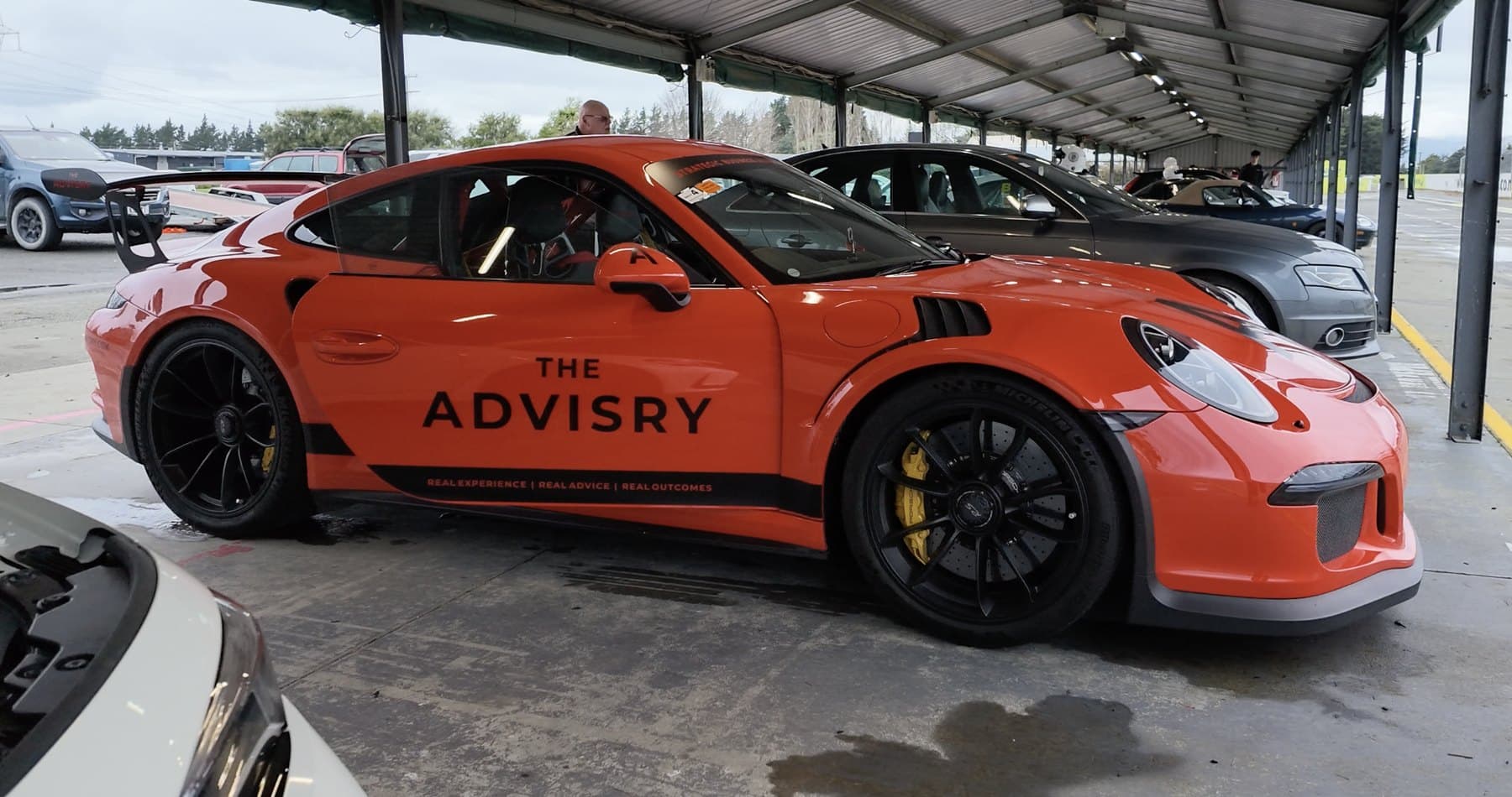 The Advisry signwritten Porsche GT3 RS at the track